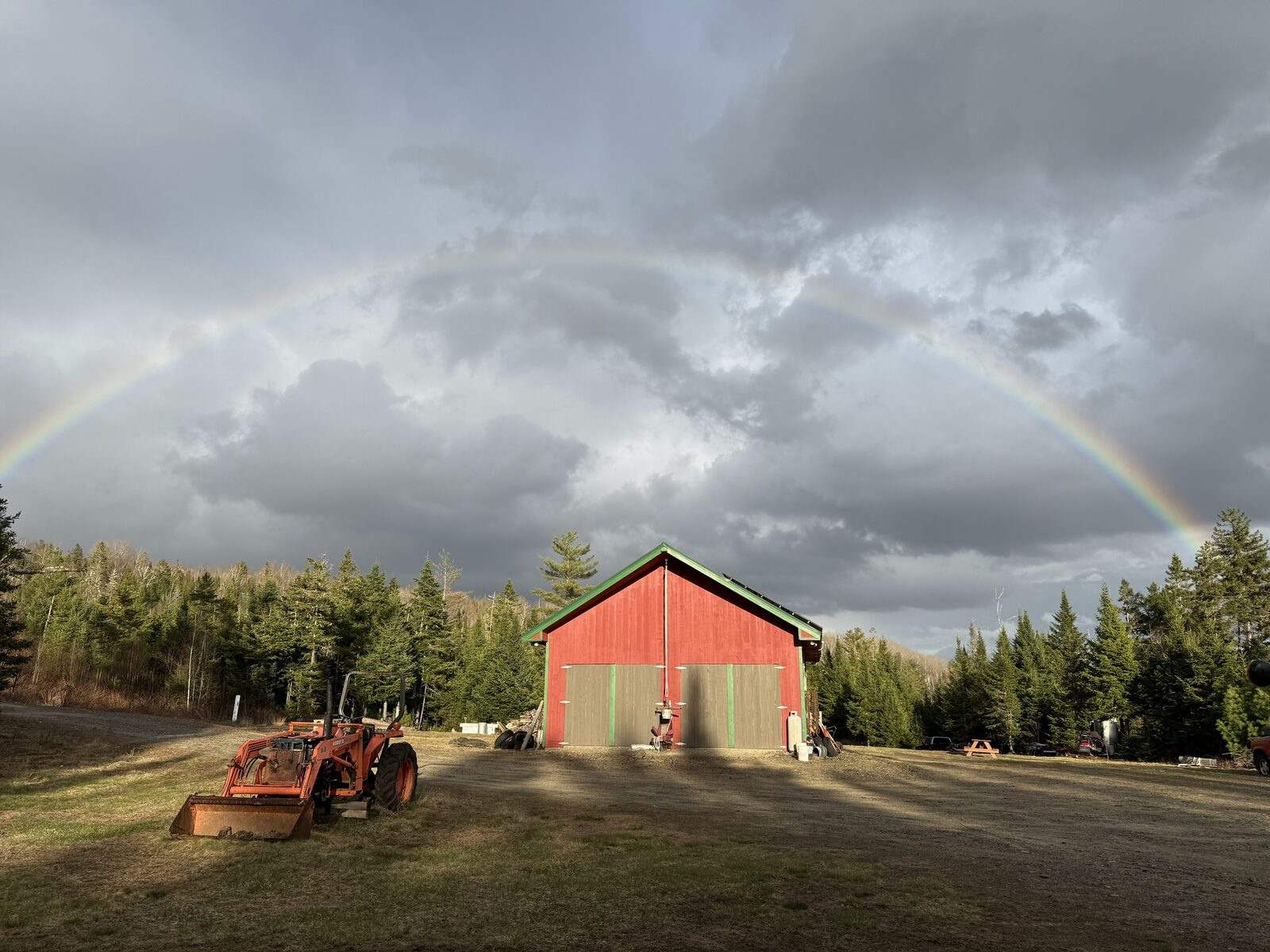 The Legacy Acres barn under a rainbow after a storm