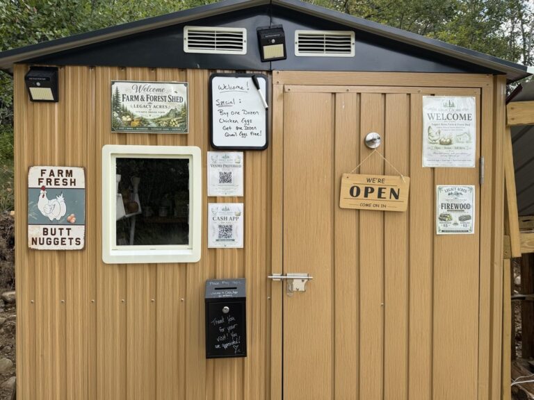 Front of the Legacy Acres Farm and Forest Shed with signs on the door