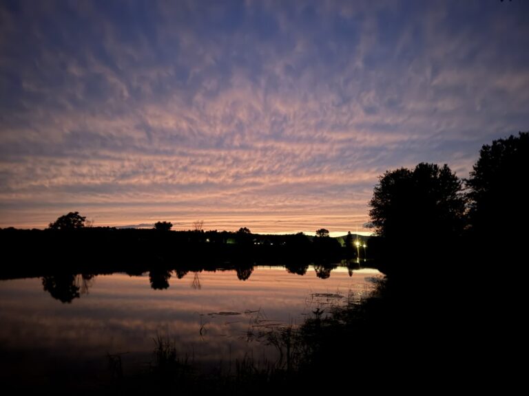 Pink and lavender evening sky reflected in calm water
