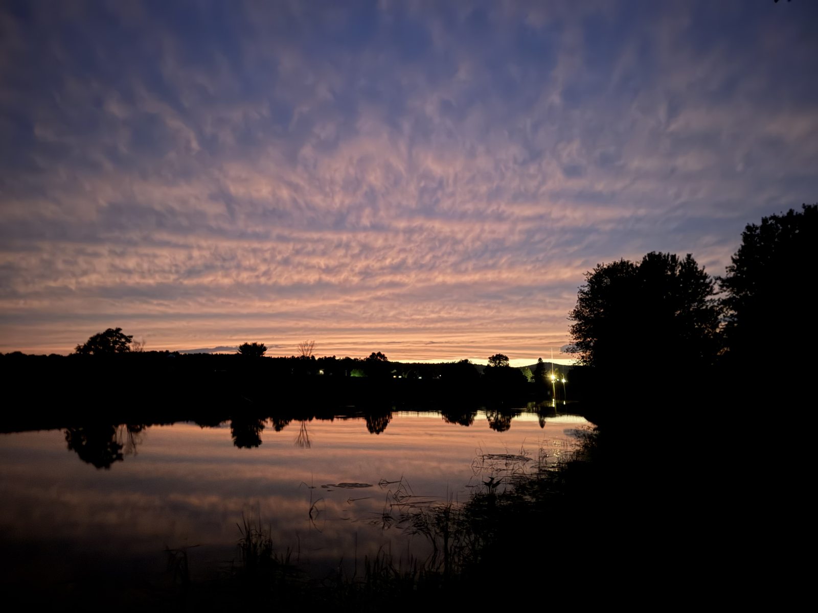 Pink and lavender evening sky reflected in calm water