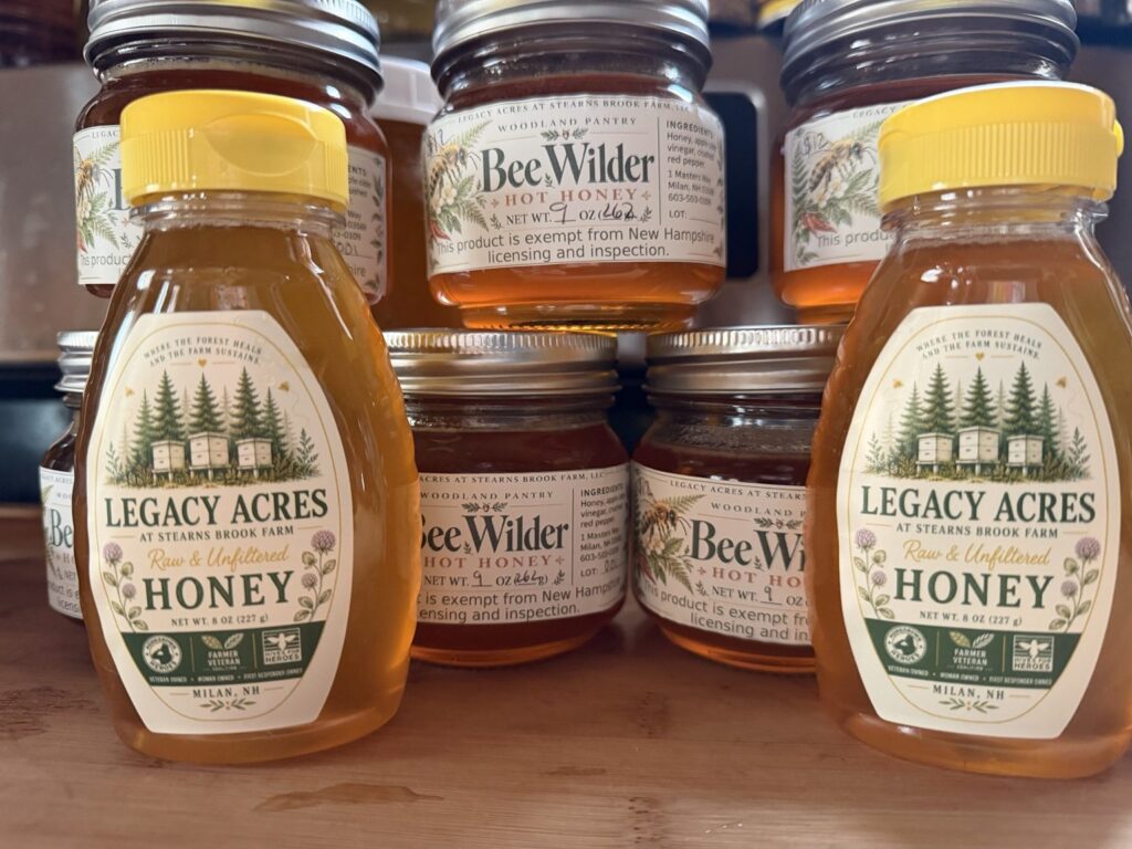 Bottled Legacy Acres honey beside Bee Wilder hot honey jars